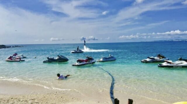 沖縄のビーチでジェットスキーを楽しむ家族と青い海