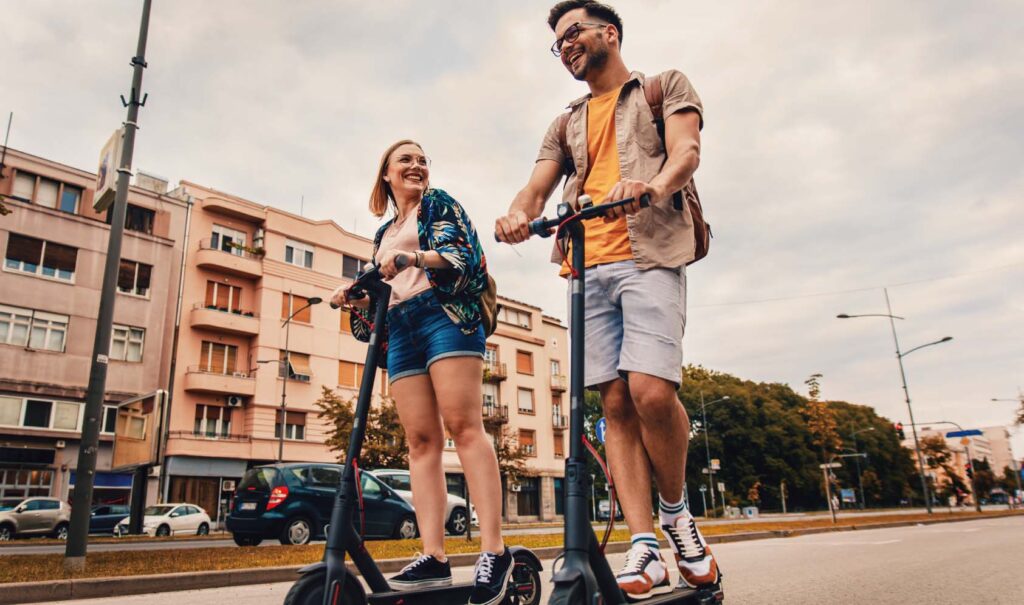 街中を電動キックボードで移動する男女