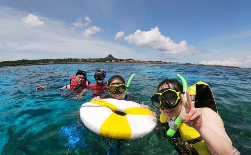 伊江島　海に浮かびながら笑顔を見せるシュノーケリング姿の男女4人