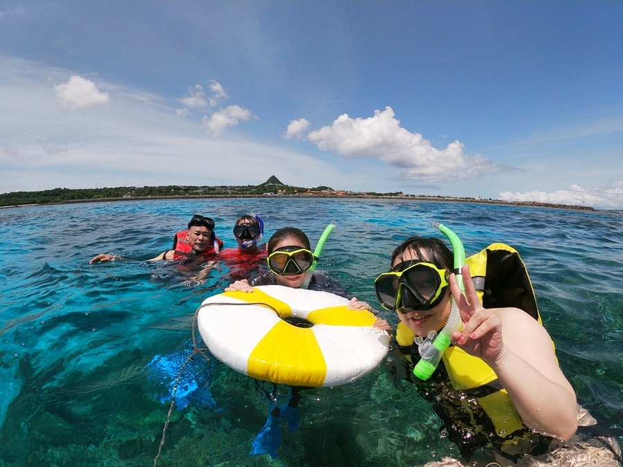伊江島　海に浮かびながら笑顔を見せるシュノーケリング姿の男女4人