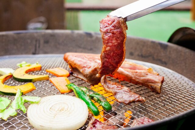沖縄BBQで肉や野菜を焼くグリルと焼きたてのステーキ
