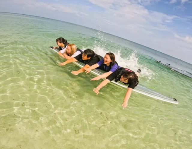 仲間と沖縄の海でSUPアクティビティ