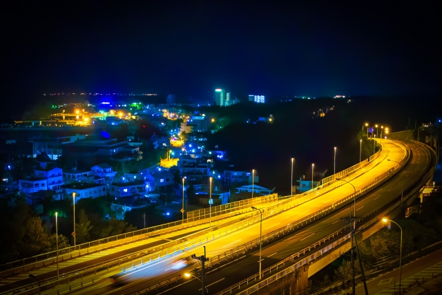 恩納村のリゾートエリアを走り抜ける道路と街灯りの夜景