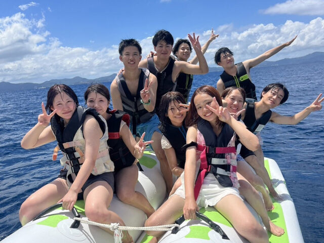 グループの伊江島ツアーでバナナボートを楽しむ8人の男女