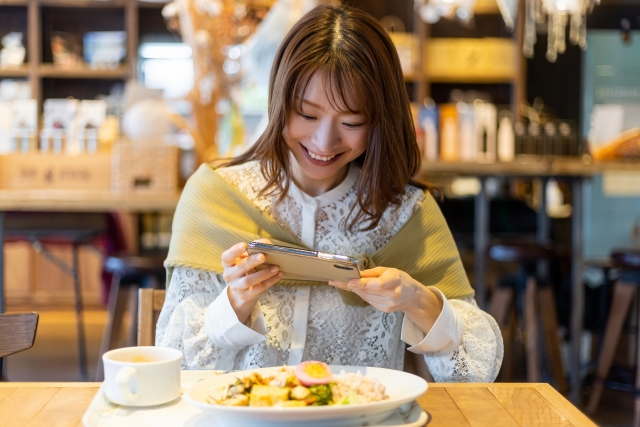 沖縄のカフェでフォトジェニックな写真を撮る女性