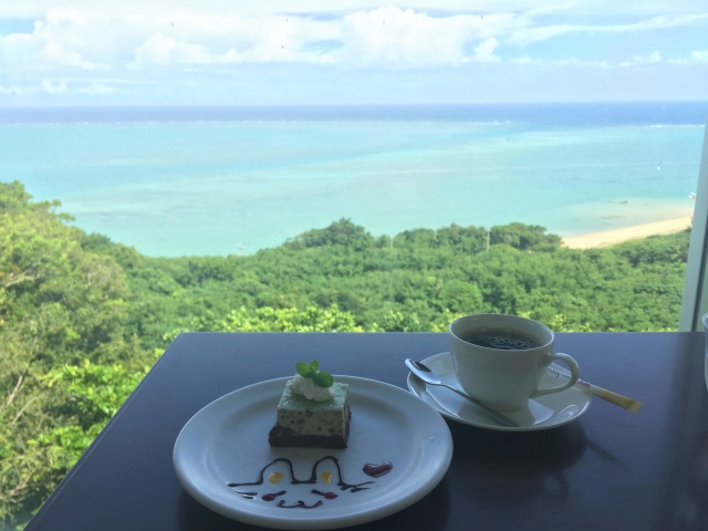 青い海を眺める沖縄カフェのケーキセット