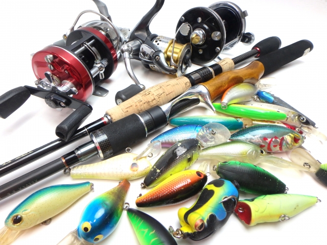沖縄のルアーフィッシングで使われる色鮮やかなルアーと数種類の釣り竿・リールのセット