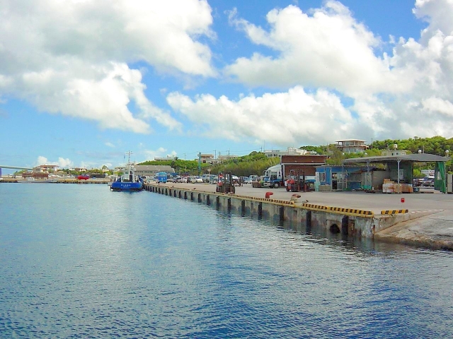 活気ある沖縄の漁港。係留された船と平坦な護岸が続く足場の良い釣り場風景。