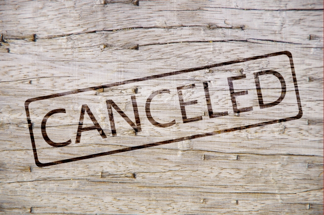 木目調の背景にスタンプされた「CANCELED」の文字。予約のキャンセル規定についてのイメージ