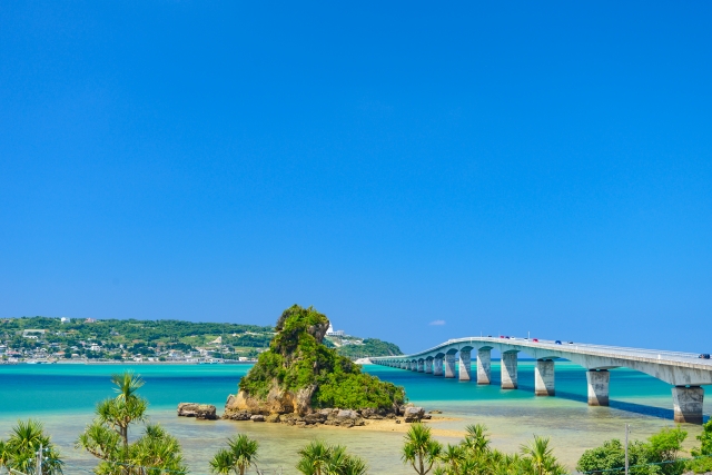 青い空と透き通る海に架かる古宇利大橋と、手前に見える小島（カエル島）