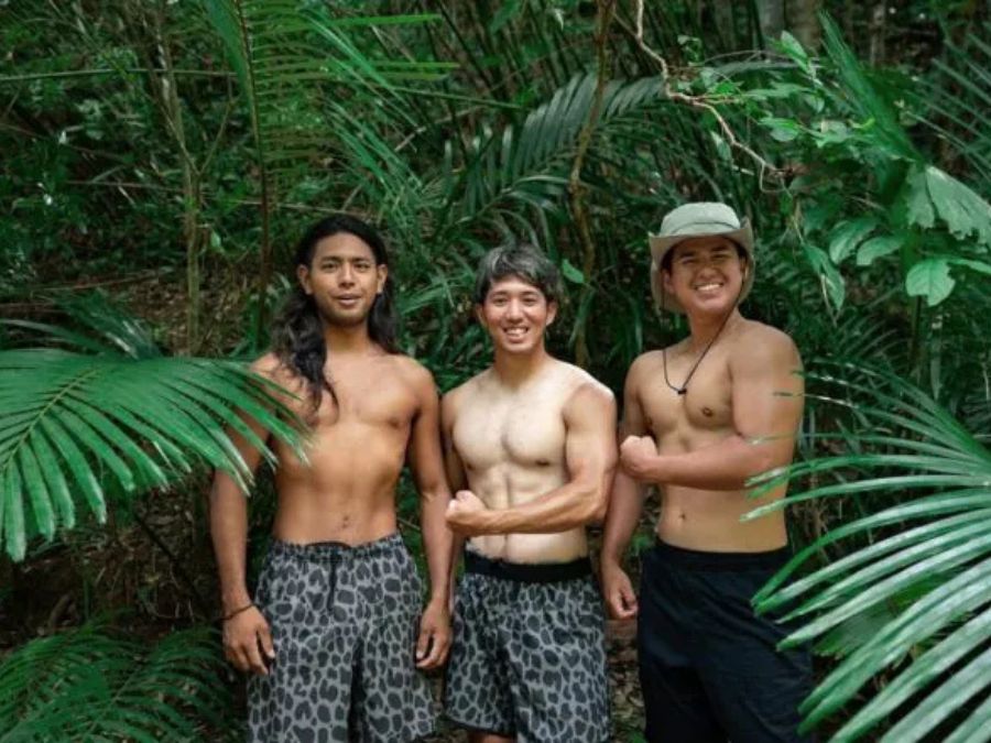 キジーの冒険風景。熱帯の森で上半身裸になりポーズをとる男性3人