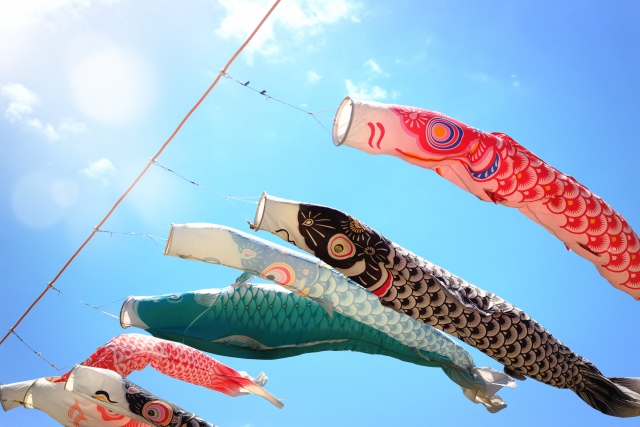 青空の下を泳ぐカラフルなこいのぼり